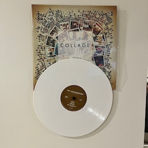 May include: A white vinyl record with a brown label that says "The Chainsmokers Collage" on it. The record is next to a brown album cover with a collage of photos on it. The album cover says "Collage" and "The Chainsmokers" on it.