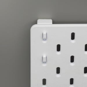Peut inclure: Un panneau perfor&eacute; rectangulaire blanc dot&eacute; d'une grille de trous ovales verticaux r&eacute;guli&egrave;rement espac&eacute;s. Le panneau pr&eacute;sente une finition mate lisse et comprend un petit support de montage blanc fix&eacute; sur le bord sup&eacute;rieur.