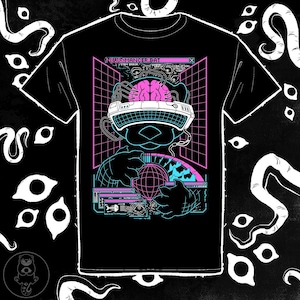 May include: Black t-shirt with a neon graphic of a figure wearing a virtual reality headset, holding a globe. The design includes pink and blue grid lines, a brain, and the text "NEUROMANCER.BAT".