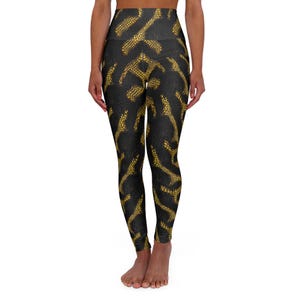 May include: Black yoga leggings with a high waist and a gold snake skin pattern.