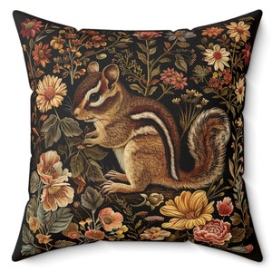 May include: A throw pillow with a black background featuring a detailed illustration of a chipmunk surrounded by colorful flowers and foliage.
