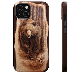 May include: A wood-burned phone case with a brown bear walking through a forest. The bear is in the center of the image and is facing the viewer. The background is a wood-grain pattern.