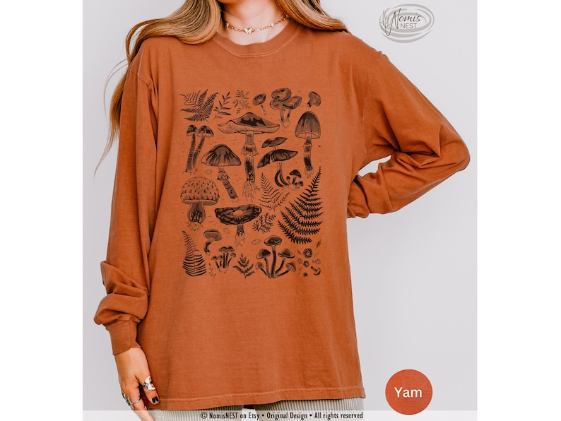 A yam colored Comfort Colors long sleeve mushroom graphic t-shirt featuring illustrated botanical mushrooms which is perfect for granola girls, mushroom fans, those seeking a forestcore aesthetic, or nature lovers.
