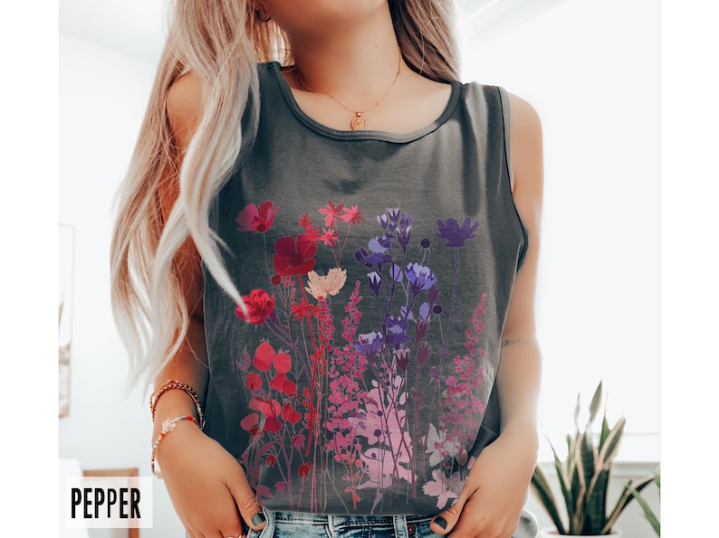 A model is wearing a Comfort Colors tank top with pressed wildflowers in a mix of reds, berries, and pastel colors.