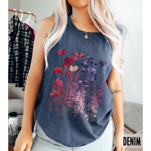 A model is wearing a Comfort Colors tank top with pressed wildflowers in a mix of reds, berries, and pastel colors.
