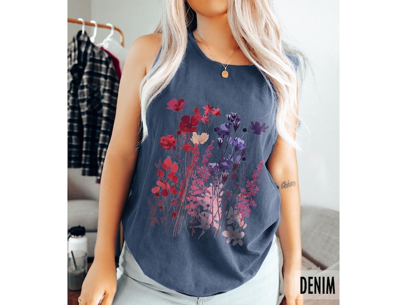 A model is wearing a Comfort Colors tank top with pressed wildflowers in a mix of reds, berries, and pastel colors.