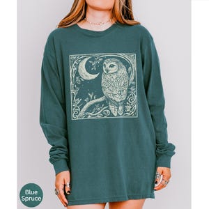 A long sleeve Comfort Colors graphic t-shirt with a linocut style Snowy Owl evoking a witchy, magical, & Dark Academia vibe.