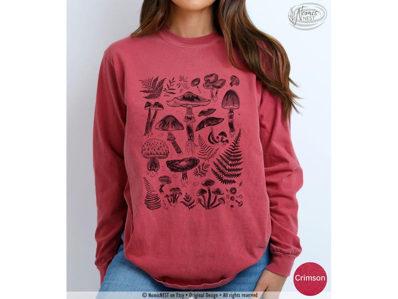 A crimson colored Comfort Colors long sleeve mushroom graphic t-shirt featuring illustrated botanical mushrooms which is perfect for granola girls, mushroom fans, those seeking a forestcore aesthetic, or nature lovers.
