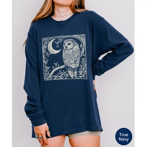 A long sleeve Comfort Colors graphic t-shirt with a linocut style Snowy Owl evoking a witchy, magical, & Dark Academia vibe.