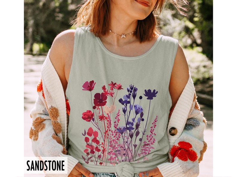 A model is wearing a Comfort Colors tank top with pressed wildflowers in a mix of reds, berries, and pastel colors.