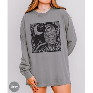 A long sleeve Comfort Colors graphic t-shirt with a linocut style Snowy Owl evoking a witchy, magical, & Dark Academia vibe.