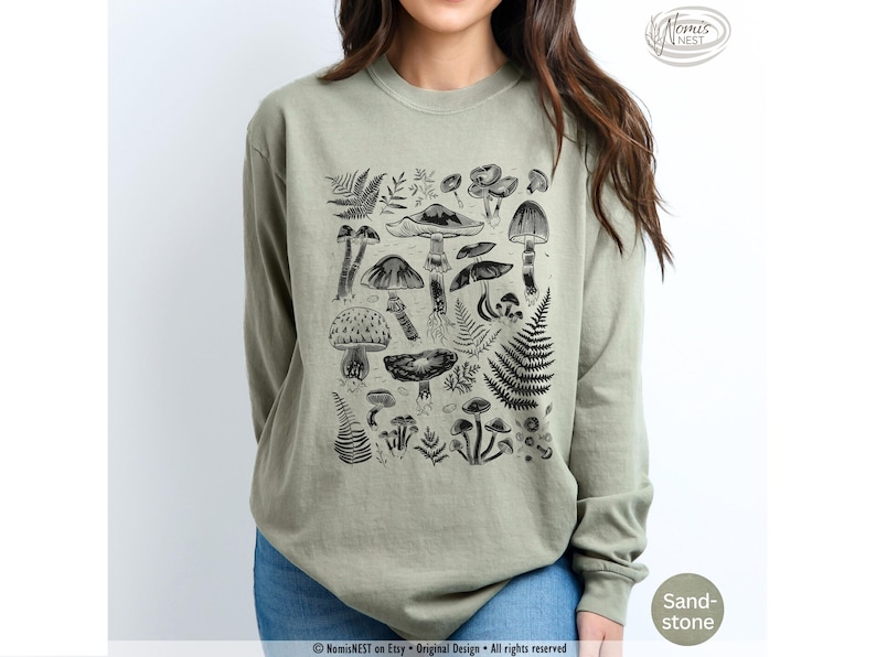 A sandstone colored Comfort Colors long sleeve mushroom graphic t-shirt featuring illustrated botanical mushrooms which is perfect for granola girls, mushroom fans, those seeking a forestcore aesthetic, or nature lovers.