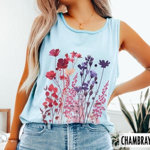 A model is wearing a Comfort Colors tank top with pressed wildflowers in a mix of reds, berries, and pastel colors.