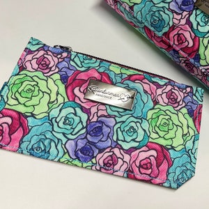 Kartenetui aus türkisblauem, glänzendem Kunstleder und wasserabweisendem Canvas, bedruckt mit bunten Rosen