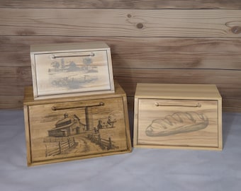 Könnte beinhalten: Drei Holzbrotboxen mit verschiedenen Designs. Die obere Box hat ein Schwarzweißbild eines Bauernhauses. Die mittlere Box hat ein Schwarzweißbild einer Scheune und eines Silos. Die untere Box hat ein Schwarzweißbild eines Laibes Brot.