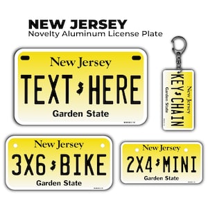 May include: A collection of novelty aluminum license plates and a keychain. The plates are yellow with black text that reads "New Jersey" and "Garden State." One plate says "TEXT HERE." The keychain has "KEY CHAIN" printed on it.