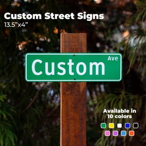 Puede incluir: Un letrero de calle verde con texto blanco que dice "Custom Ave". El letrero mide 34.3 cm x 10.2 cm y está montado en un poste de madera. El texto "Custom Street Signs" está en la parte superior. Disponible en 10 colores.