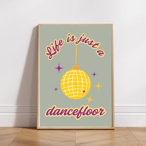 May include: A light grey poster with the text "Life is just a dancefloor" in purple and yellow lettering. A yellow disco ball hangs from the ceiling with purple stars in the background.