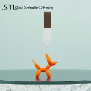 May include: An orange balloon animal shaped like a dog is hanging from a white and brown keychain. The keychain is attached to a ring. The text ".STL Digital Download for 3D Printing" is visible in the background.