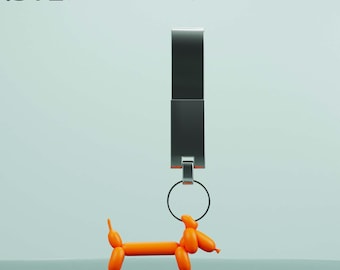 Puede incluir: Un llavero plateado con un anillo y un animal de globo naranja brillante con forma de dachshund.