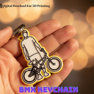 May include: A yellow BMX keyring featuring a black and white illustration of a person with a bicycle. The keyring has a silver ring and the text "BMX KEYCHAIN" in purple and blue. The image also includes the text ".STL Digital Download For 3D Printing".