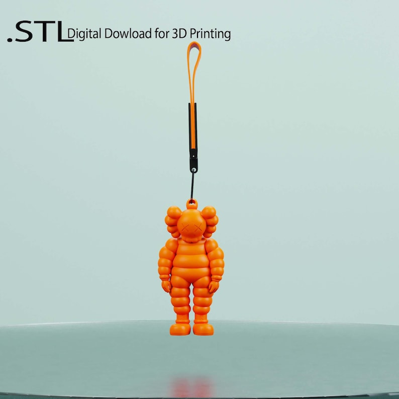 May include: Orange figurine with a loop and strap, suspended against a light background. The figurine is a stylized character with a round head and a distinctive pose. The text ".STL Digital Download for 3D Printing" is visible.