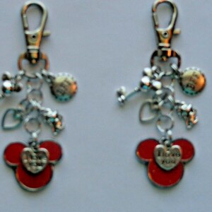May include: Two keychains with silver-tone charms and red Mickey Mouse-shaped pendants. Each keychain has a lobster clasp, charms, and a heart-shaped pendant with the words "I love you."
