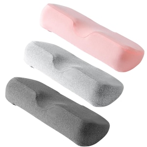 May include: Three ergonomic pillows in pink, grey, and dark grey. Each pillow has a curved design with a central indentation. The pillows are made of a soft, textured material, and are designed for comfort and support.