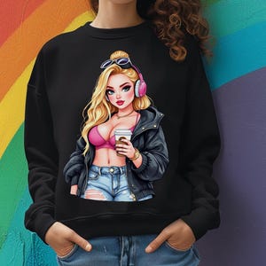 以下が含まれることがあります： 黒いスウェットシャツ。金髪、サングラス、ピンクのヘッドフォンをした女性の漫画イラストが描かれています。ピンクのトップス、デニムショーツ、黒いジャケットを着て、コーヒーカップを持っています。背景はカラフルな虹です。