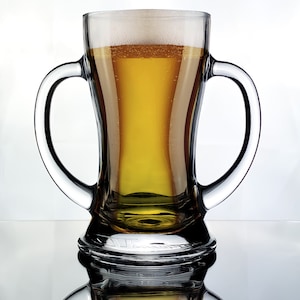 May include: A clear glass beer mug with two handles, filled with a light golden beer and a white head of foam.