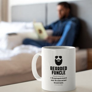 May include: White ceramic coffee mug with a black illustration of a bearded man wearing sunglasses. The mug has the text "Bearded Funcle" and a definition of the word.