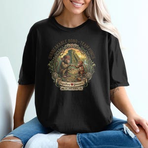 May include: Black t-shirt featuring a detailed illustration of two monkeys in a jungle setting, with the words "Unbreakable Bond - Team Punch" and "together forever" printed on the front. The design is framed by a decorative border.