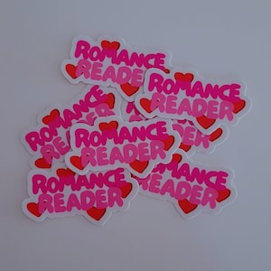 Puede incluir: Un montón de pegatinas rosas y rojas con el texto "Romance Reader" y un diseño de corazón.