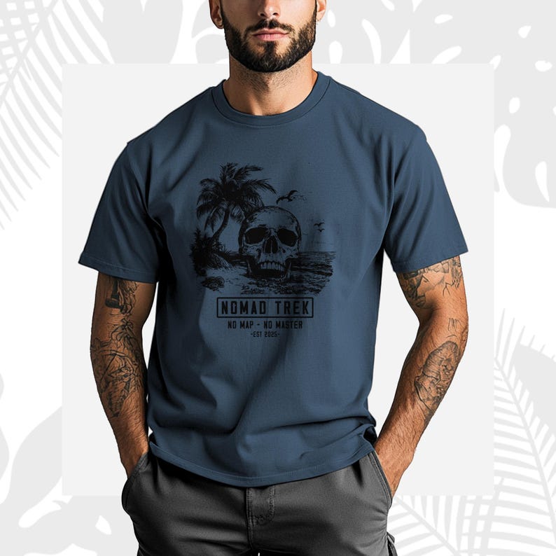 K&ouml;nnte beinhalten: Ein marineblaues T-Shirt mit einer schwarzen Grafik eines Sch&auml;dels an einem Strand mit Palmen und V&ouml;geln. Der Text "NOMAD TREK" ist darunter aufgedruckt, zusammen mit den S&auml;tzen "NO MAP - NO MASTER" und "EST 2020".