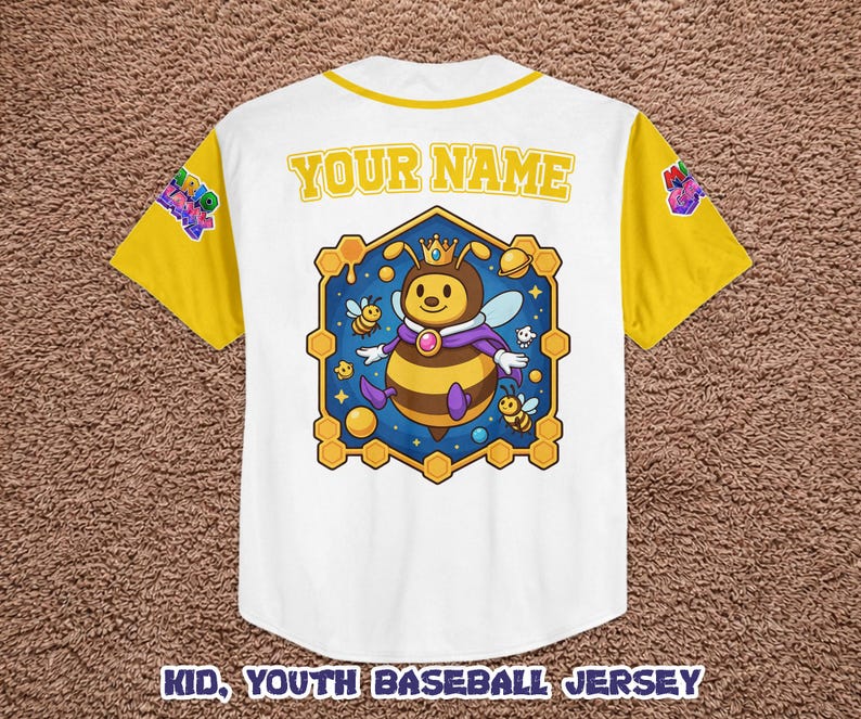 Puede incluir: Camiseta de b&eacute;isbol blanca para ni&ntilde;os con mangas y cuello amarillos. La camiseta presenta un personaje de abeja de dibujos animados con una corona y una capa dentro de un marco hexagonal. El texto "YOUR NAME" est&aacute; encima del gr&aacute;fico y "KID, YOUTH BASEBALL JERSEY" debajo.