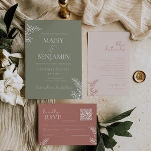 Puede incluir: Conjunto de invitaciones de boda con una invitación verde salvia con detalles florales blancos y los nombres "Maisy & Benjamin". También se incluye una tarjeta de detalles rosa rubor y una tarjeta RSVP con un código QR. El conjunto está sobre un fondo neutro.
