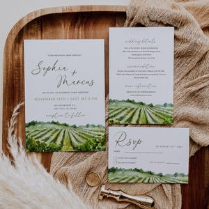 Könnte beinhalten: Hochzeitseinladungs-Set mit einem Aquarell-Weinberg-Design. Das Set beinhaltet eine Einladung, eine Detailkarte und eine RSVP-Karte. Die Einladung lautet "Sophia + Marcus" und das Datum, 12. November 2027.