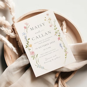 May include: A wedding invitation with a floral border. The invitation reads "Maisy and Callan invite you to celebrate their wedding! 19 October 2025 at 2 PM Really Great Site Hotel 123 Anywhere Street, Any City Dinner and dancing to follow"