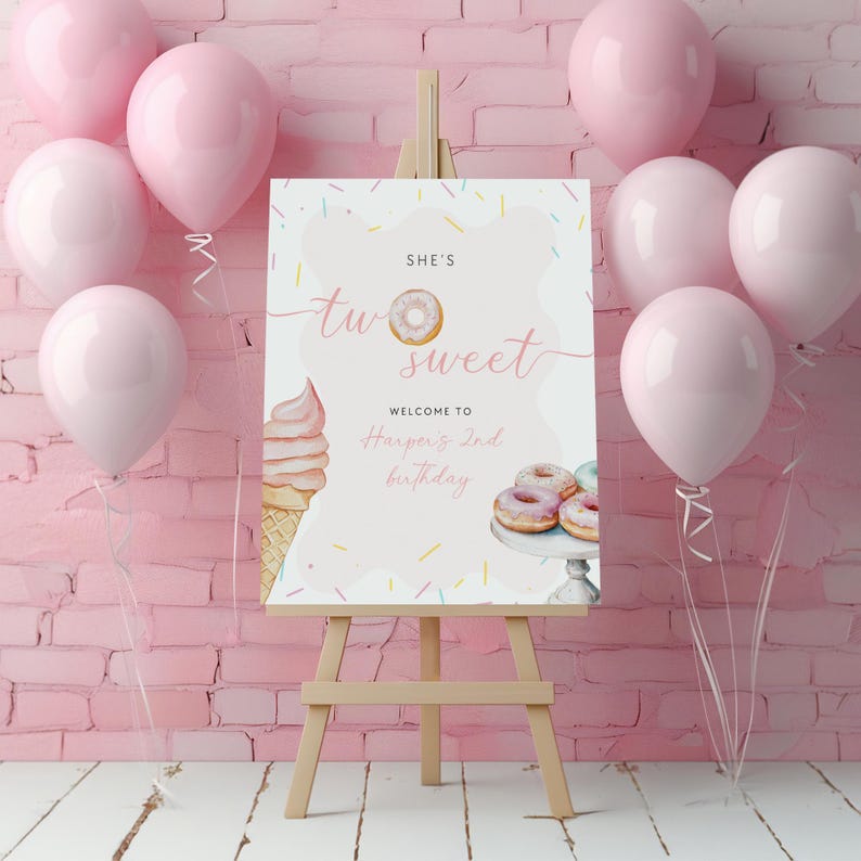 May include: A wooden easel holds a pink and white sign with the text "She's Two Sweet" and "Welcome to Harper's 2nd Birthday." The sign includes illustrations of a donut, ice cream cone, and donuts. Pink balloons are arranged around the easel.