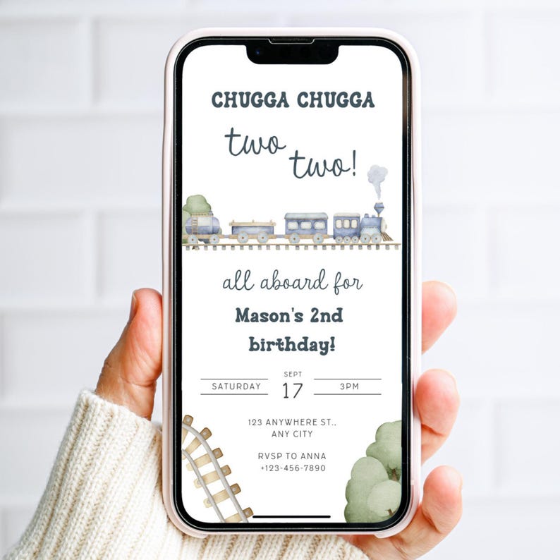 May include: A smartphone displays a birthday invitation with a train theme. The text reads "CHUGGA CHUGGA two two!" and "all aboard for Mason's 2nd birthday!" Details include date, time, and RSVP information. Watercolor train illustration.