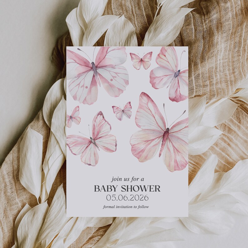 Puede incluir: Una tarjeta blanca con una ilustraci&oacute;n de acuarela de mariposas rosas. El texto en la tarjeta dice "join us for a BABY SHOWER 05.06.2026 formal invitation to follow."