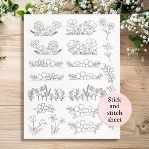 May include: A white stick and stitch sheet featuring various floral designs in black line art. The sheet includes detailed illustrations of daisies, poppies, and other flowers, perfect for embroidery or crafting projects.