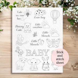 Könnte beinhalten: Ein weißes Stick- und Stichblatt mit verschiedenen Baby-Illustrationen in schwarzer Umrandung. Designs umfassen eine Biene, einen Marienkäfer, einen Heißluftballon, einen Teddybären, eine Sonne, einen Schmetterling, ein Lamm, einen Elefanten, ein Kaninchen und das Wort "BABY".