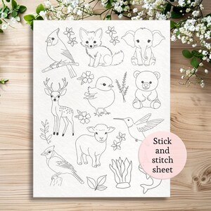 May include: A white stick and stitch sheet featuring line art illustrations of various animals and floral elements. The sheet includes a cardinal, fox, elephant, deer, chick, bear, lamb, hummingbird, and a blue jay. The text "Stick and stitch sheet" is in a pink circle.