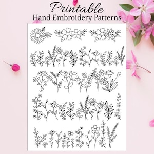 May include: A white sheet with black line drawings of various floral embroidery patterns. The text "Printable Hand Embroidery Patterns" is at the top. Pink flowers are in the background.
