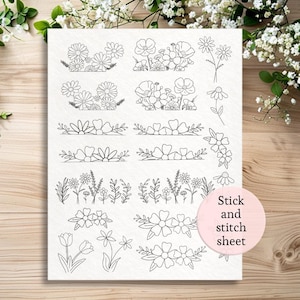 May include: A white stick and stitch sheet featuring various floral designs in black line art. The sheet includes detailed illustrations of daisies, poppies, and other flowers, perfect for embroidery or crafting projects.
