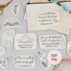 May include: A collection of white iron-on transfers featuring black line art designs including a lamb, a mountain, a candle, a cross, and floral motifs. Each design includes religious text such as Philippians 4:13 and Matthew 17:20.