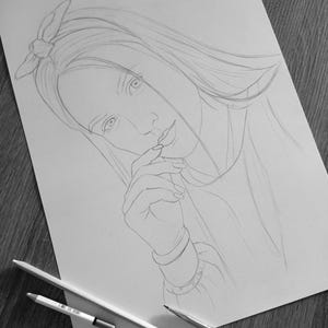 May include: A graphite pencil drawing on white paper depicting a person with long hair and a bow headband. The person has one hand raised towards their face. Two pencils are positioned at the bottom of the paper, one with a visible barcode.