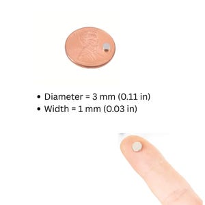 May include: A small, round, silver-coloured magnet is shown next to a U.S. penny for size comparison. The magnet's diameter is 3 mm (0.11 in), and its width is 1 mm (0.03 in). The magnet is also shown on a fingertip.