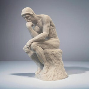 May include: A white marble sculpture of a man sitting and thinking. The sculpture is a replica of the famous "The Thinker" by Auguste Rodin.